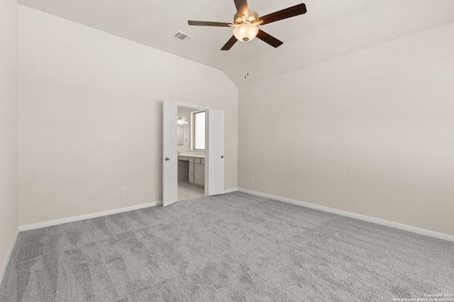 unfurnished bedroom featuring ceiling fan, light colored carpet, connected bathroom, and vaulted ceiling