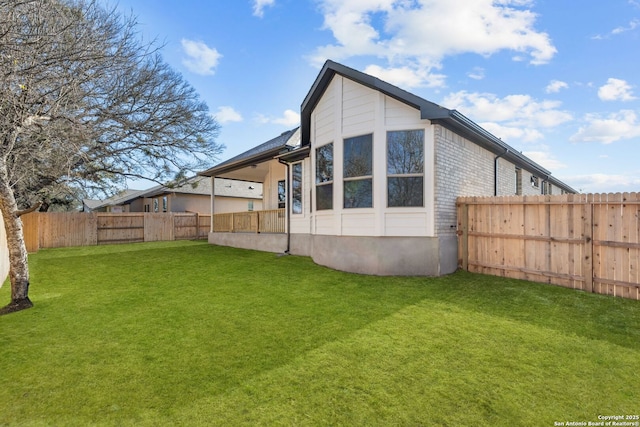 rear view of property featuring a lawn