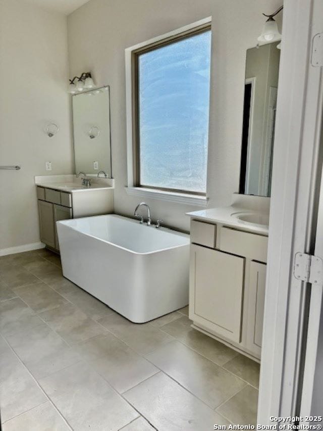 bathroom featuring vanity, a bathtub, and tile patterned flooring