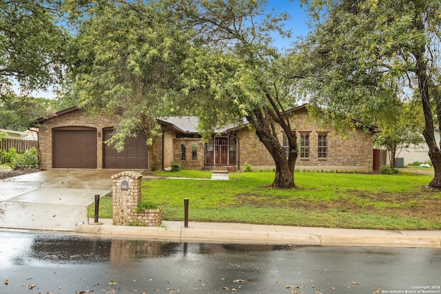 mid-century modern home featuring fence, a front lawn, concrete driveway, and brick siding