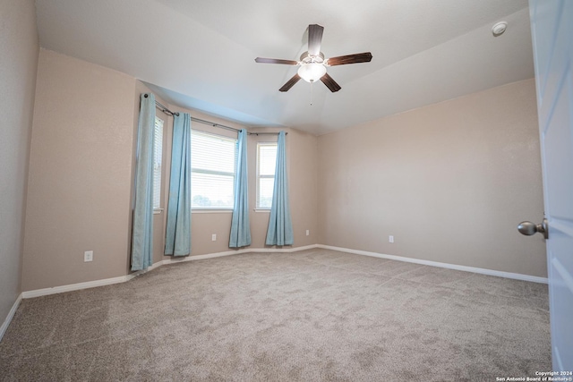 unfurnished room with light colored carpet, vaulted ceiling, and ceiling fan