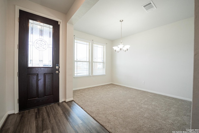 foyer entrance featuring a chandelier and dark hardwood / wood-style flooring