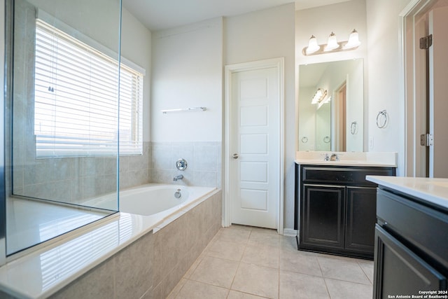 bathroom featuring vanity, tiled bath, and tile patterned flooring