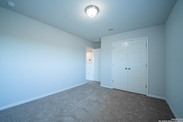 unfurnished bedroom featuring carpet floors and a closet