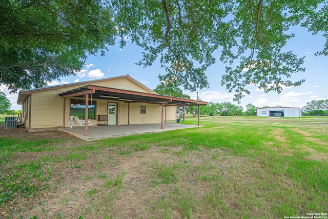 rear view of property featuring a patio, central air condition unit, and a lawn