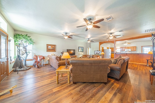 living room featuring a healthy amount of sunlight, ceiling fan, and hardwood / wood-style floors