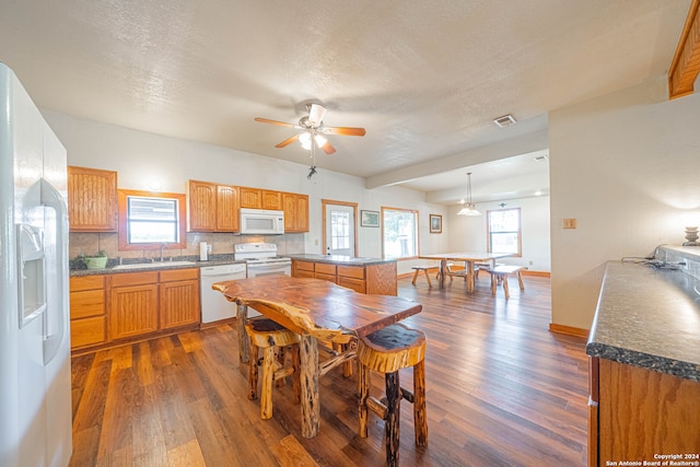 dining room featuring dark hardwood / wood-style floors, a textured ceiling, sink, and ceiling fan