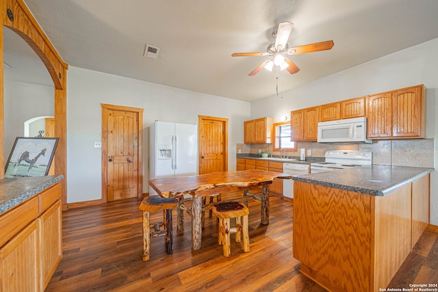 kitchen with white appliances, kitchen peninsula, backsplash, dark wood-type flooring, and ceiling fan