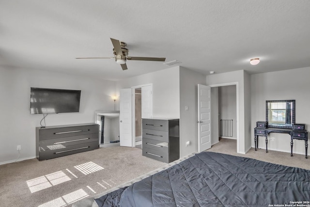 bedroom featuring light carpet, a textured ceiling, and ceiling fan