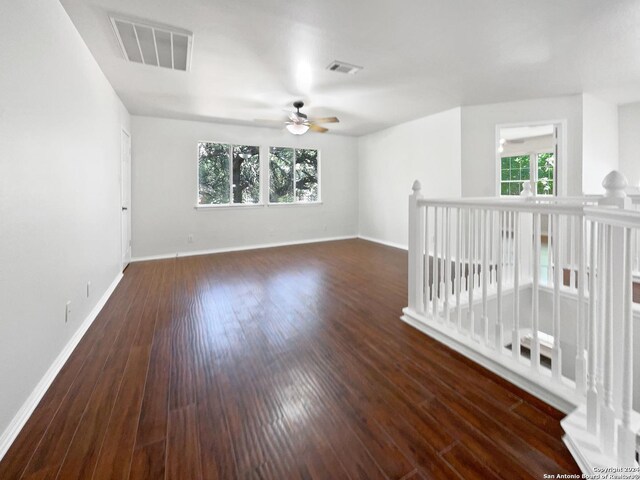 empty room with ceiling fan and dark wood-type flooring