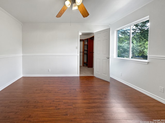 empty room featuring ornamental molding, ceiling fan, and dark hardwood / wood-style floors