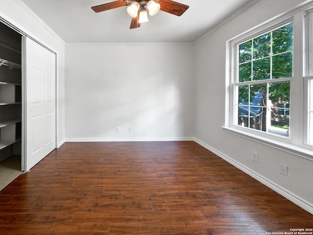 unfurnished bedroom with ornamental molding, a closet, ceiling fan, and dark wood-type flooring