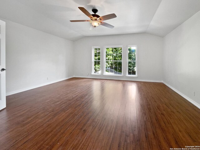 spare room featuring ceiling fan, dark hardwood / wood-style flooring, and lofted ceiling