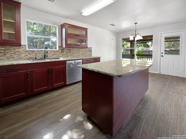 kitchen featuring stainless steel dishwasher, dark hardwood / wood-style flooring, sink, a center island, and backsplash