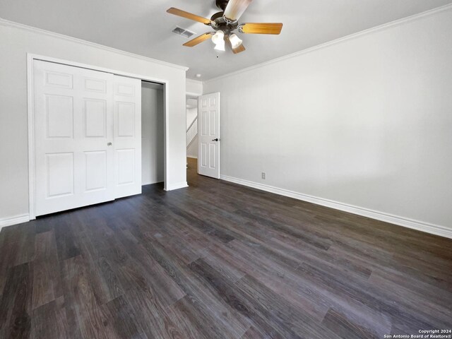 unfurnished bedroom with crown molding, ceiling fan, dark hardwood / wood-style floors, and a closet