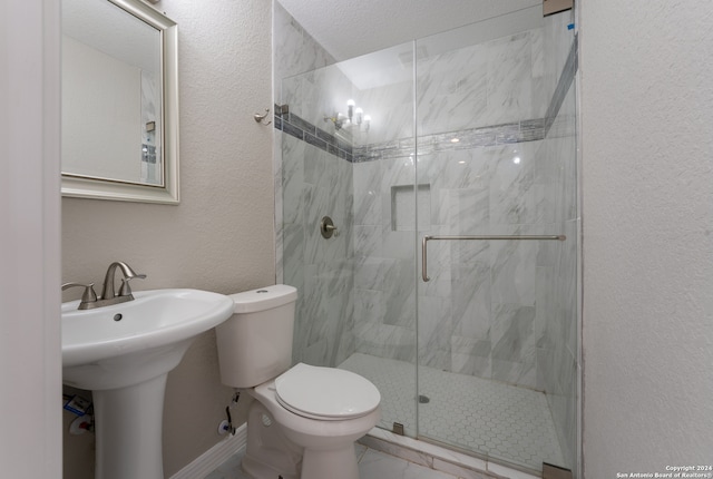 bathroom featuring a shower with shower door, toilet, tile patterned floors, and a textured ceiling