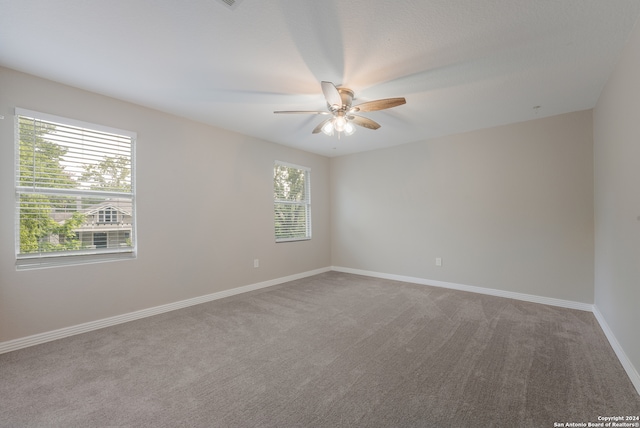 carpeted spare room with a healthy amount of sunlight and ceiling fan