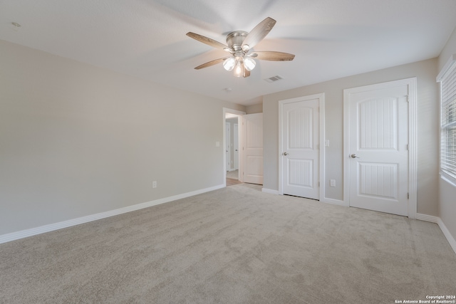 unfurnished bedroom with ceiling fan and light colored carpet