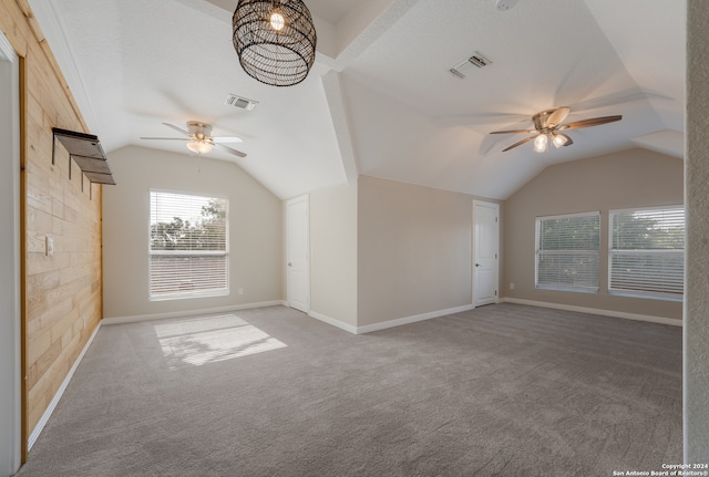 bonus room featuring wood walls, ceiling fan, and carpet flooring