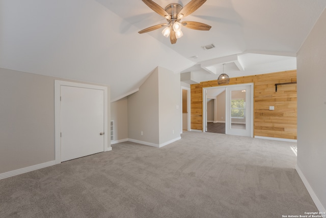 additional living space with carpet floors, wooden walls, ceiling fan, and lofted ceiling