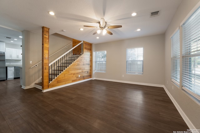 unfurnished living room featuring ceiling fan and dark hardwood / wood-style flooring