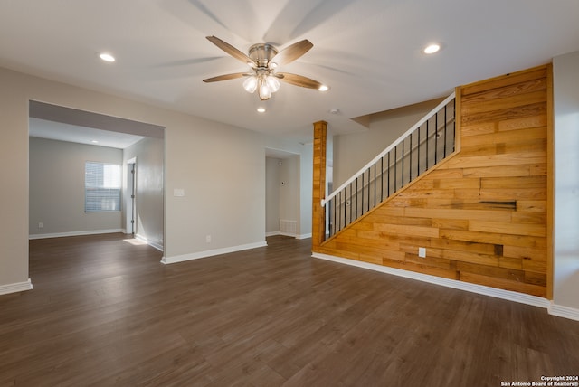 unfurnished living room with ceiling fan and dark wood-type flooring