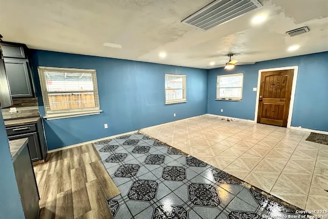 empty room with ceiling fan and light hardwood / wood-style floors