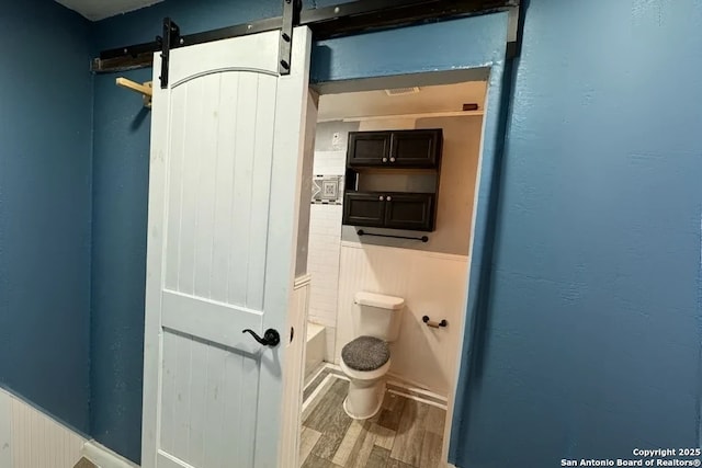 bathroom with wood-type flooring and toilet