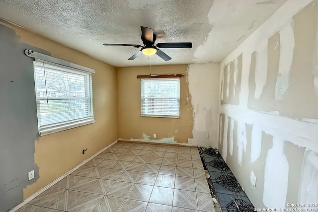 spare room featuring ceiling fan and a textured ceiling