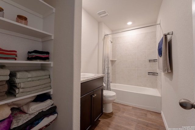 full bathroom with hardwood / wood-style flooring, vanity, toilet, and shower / bath combo with shower curtain