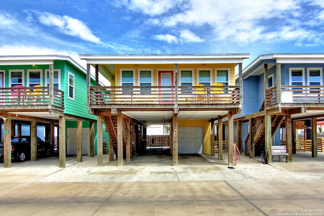 view of front facade featuring a balcony, a garage, and a carport