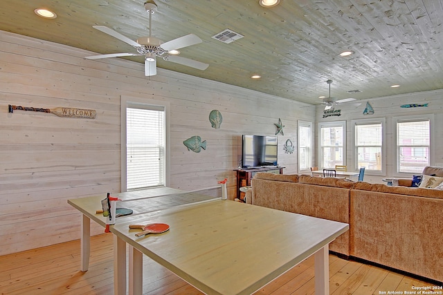 kitchen with wood walls, ceiling fan, and light wood-type flooring