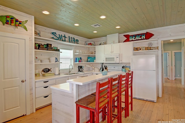 kitchen featuring wood ceiling, a center island, light wood-type flooring, and white appliances