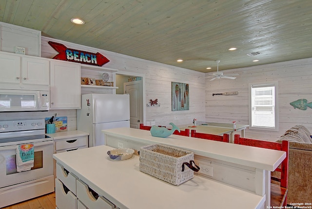 kitchen featuring white appliances, a center island, wood walls, ceiling fan, and wooden ceiling