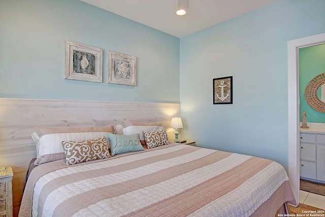 bedroom with tile patterned floors and connected bathroom