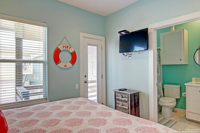 tiled bedroom featuring access to outside, connected bathroom, and multiple windows