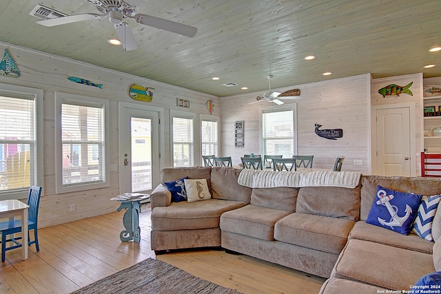 living room with wooden walls, wood ceiling, hardwood / wood-style floors, and ceiling fan