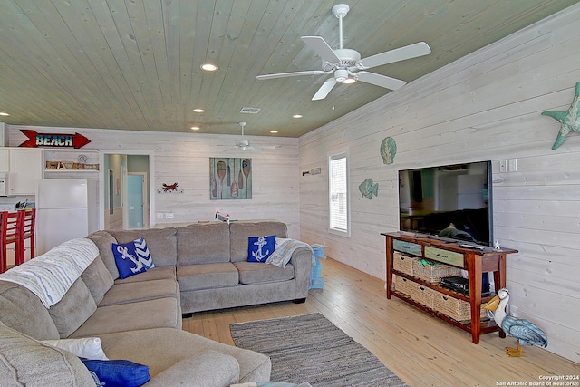 living room with light hardwood / wood-style flooring, wooden ceiling, and wooden walls