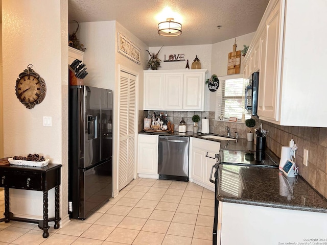 kitchen featuring white cabinets, black appliances, sink, and backsplash