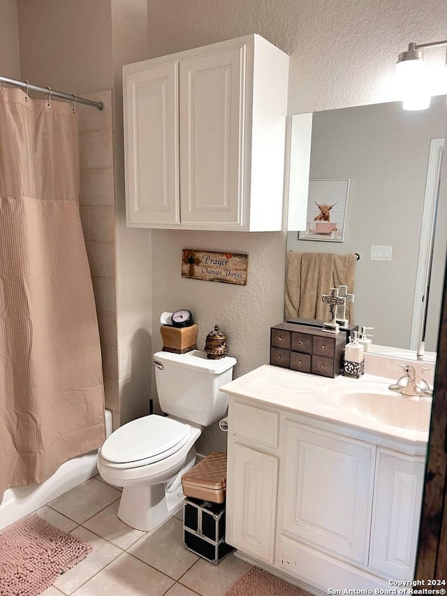 bathroom with a shower with curtain, vanity, toilet, and tile patterned floors