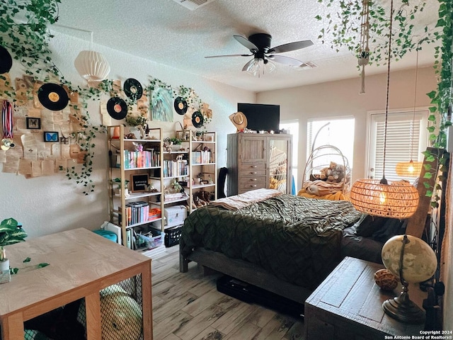 bedroom featuring wood-type flooring, a textured ceiling, and ceiling fan