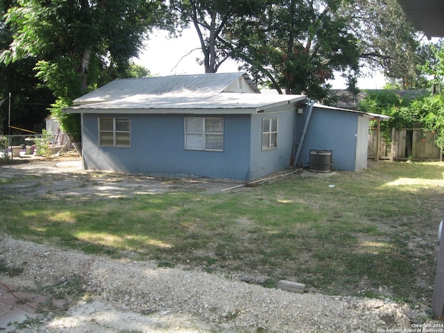 exterior space featuring central AC unit and a lawn