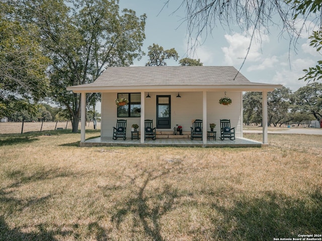 back of house featuring a porch and a lawn