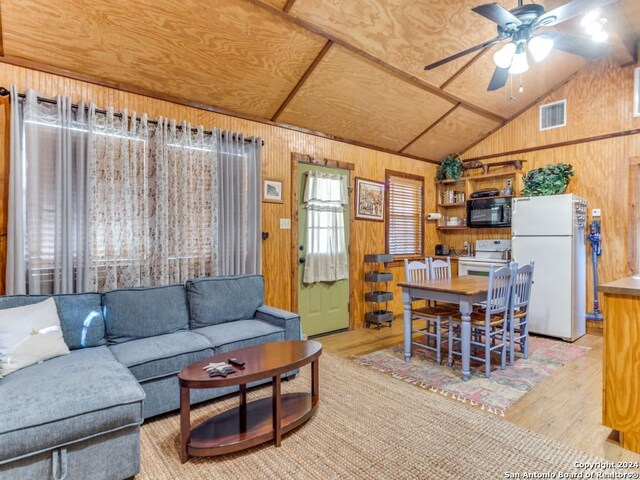 living room with wooden walls, vaulted ceiling, ceiling fan, light hardwood / wood-style flooring, and wood ceiling