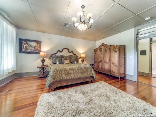 bedroom with a chandelier, wood-type flooring, and multiple windows