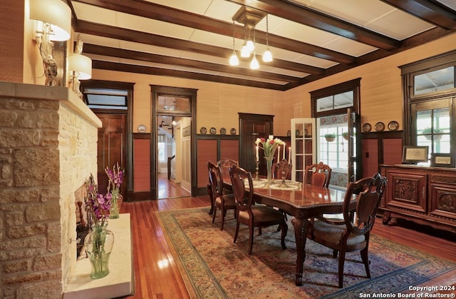 dining area featuring beam ceiling, dark wood-type flooring, and a chandelier