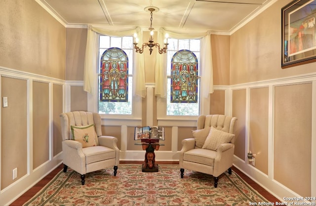 sitting room featuring a notable chandelier, crown molding, and a wealth of natural light