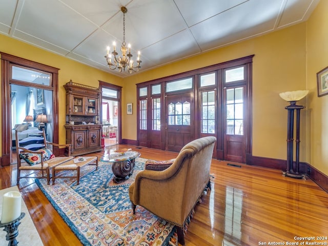 living room featuring a healthy amount of sunlight, a chandelier, and hardwood / wood-style flooring