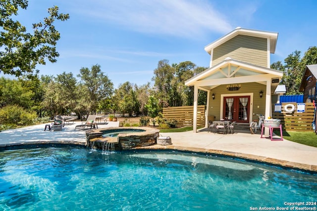 view of pool with pool water feature, an in ground hot tub, french doors, an outdoor structure, and a patio area