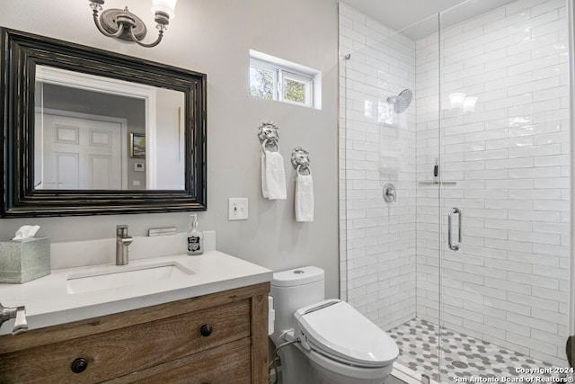 bathroom with toilet, a shower with shower door, and vanity